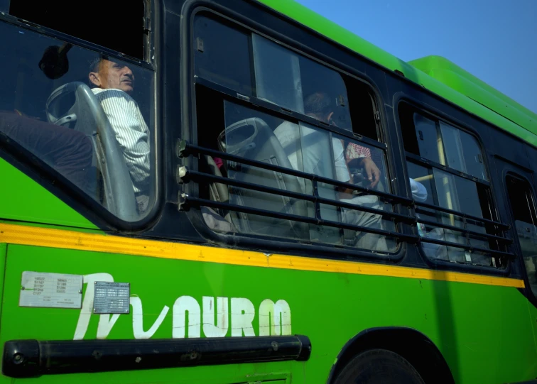 passengers sit on a bus on a city street