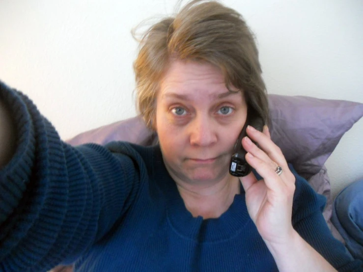 woman holding a cellphone to her ear with one hand while the other hand