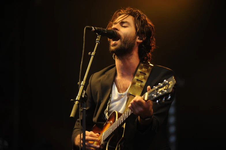 a man standing on top of a stage playing a guitar