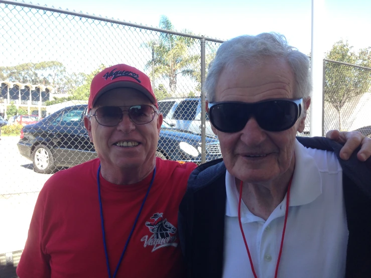 two old men standing side by side with their backs to each other