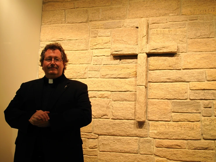 a man wearing black is standing in front of a wall