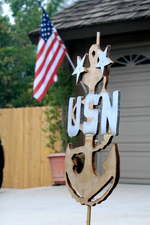 a wooden sign saying u s n with the us flag in the background