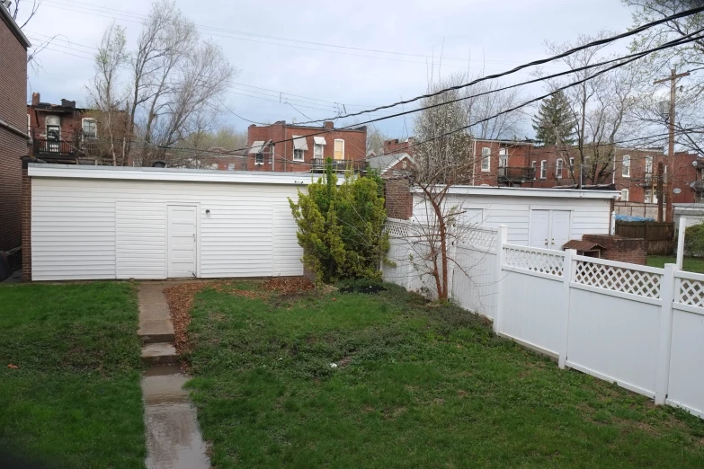 a back yard with white fences next to it