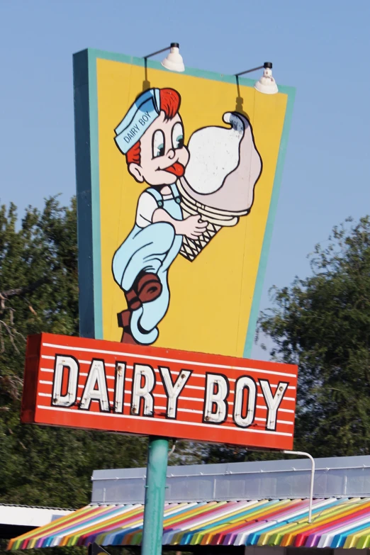 a sign for dairy boy is in front of trees