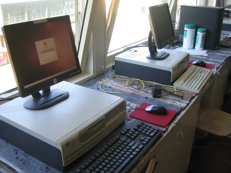 computer monitors, keyboards and mouses sitting on a desk