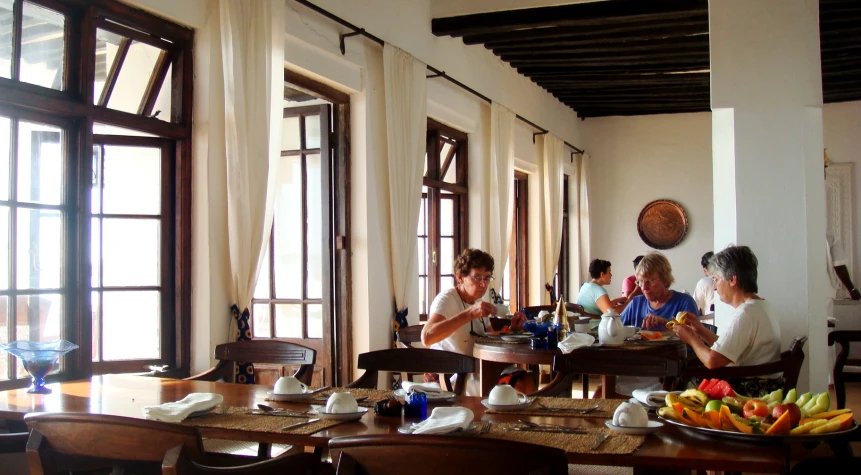 several people in a restaurant on the other side of a table