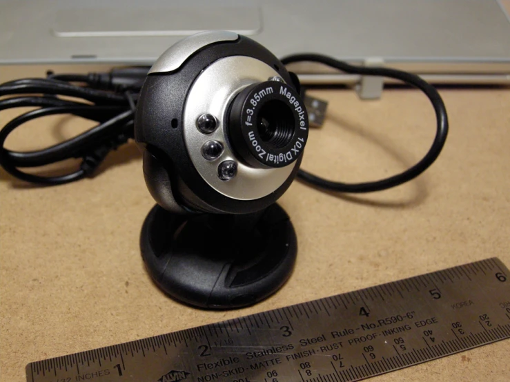 a computer security camera with the ruler beside it