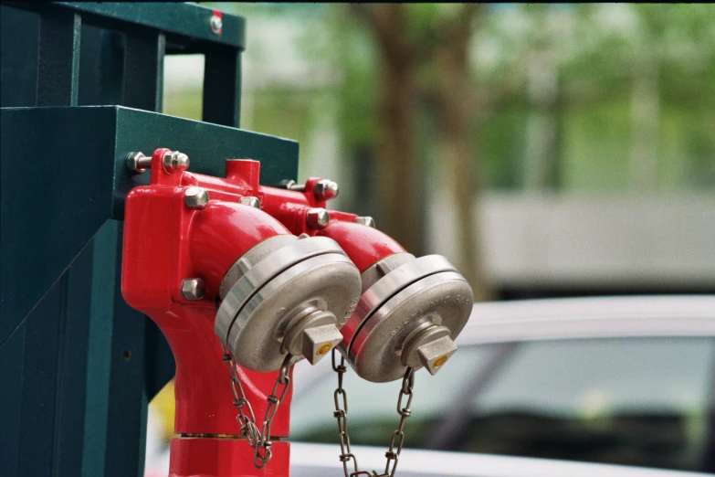 two red fire hydrants connected to green post