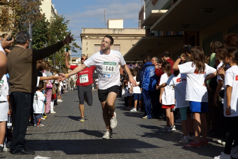 a man is running down the street, surrounded by people