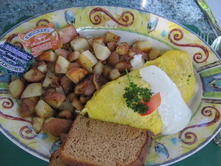 a yellow and white plate has potatoes, egg, meat, bread, and croissants on it