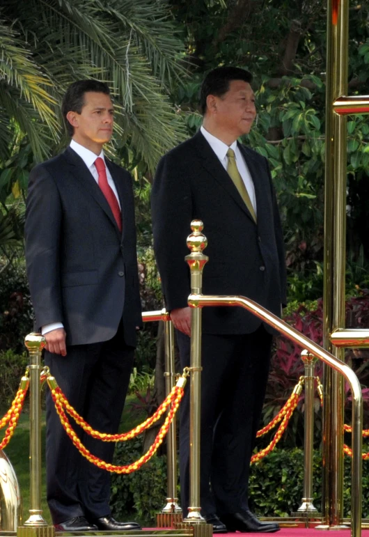 two men standing in a building by a yellow rope