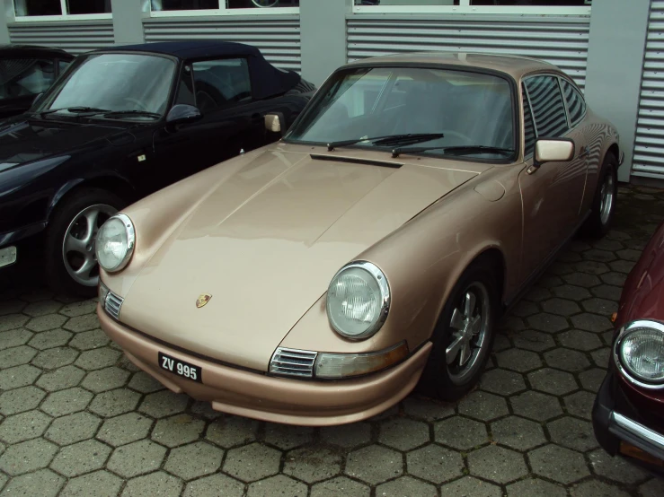 the golden porsche sits in the parking lot