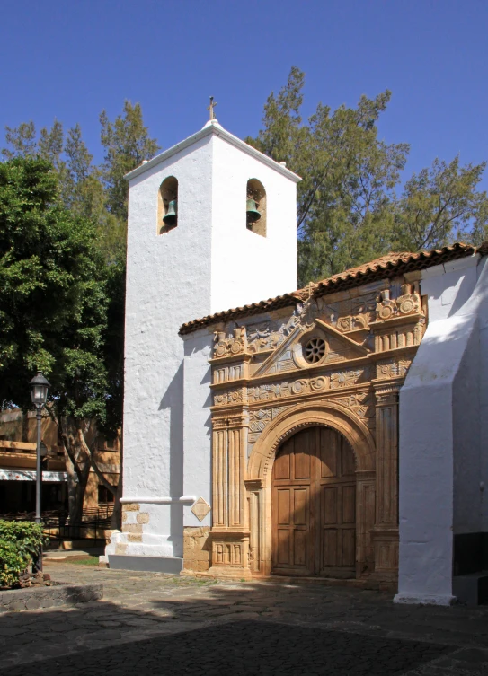 a white building with a brown door and two tall buildings