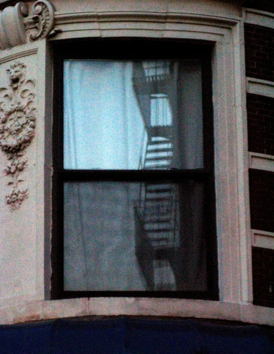 looking up at the sky and onto a window with a spiral staircase in it