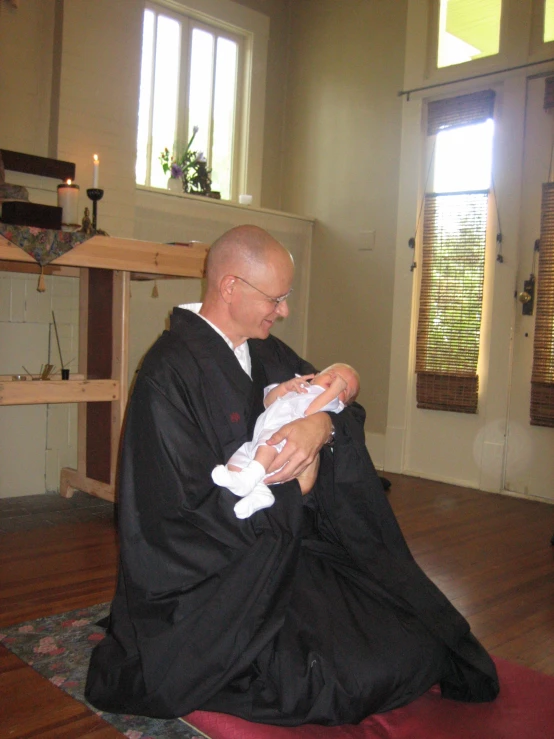 a man is dressed up and holding a small baby