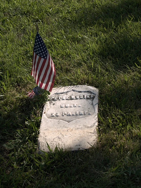 an american flag sits on a small memorial