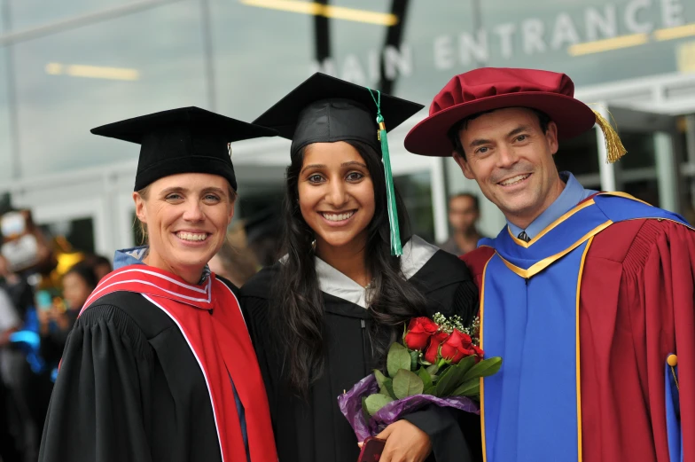 two graduates posing for a pograph with their family