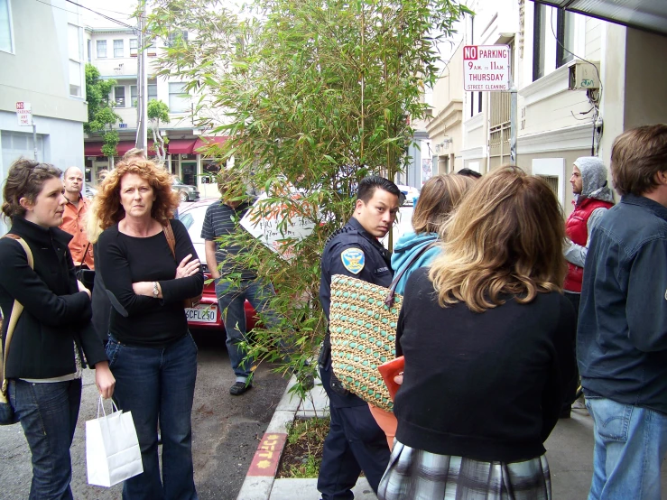 a group of people stand on the sidewalk next to the sidewalk