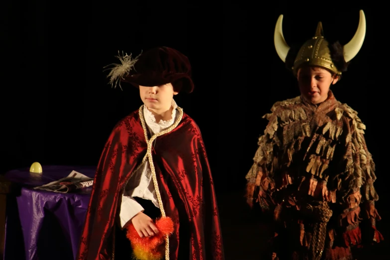 two children dressed as characters standing in the dark