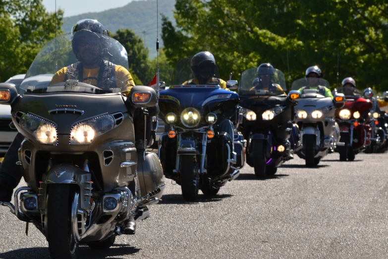 a group of motorcyclists riding down the road