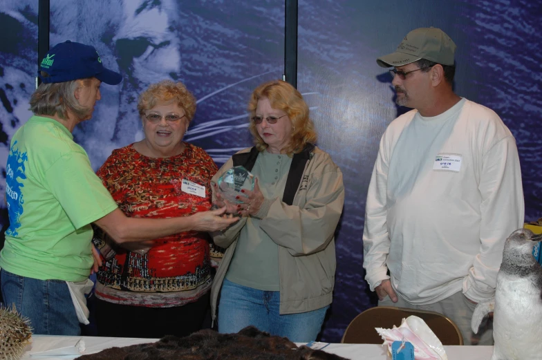 a group of people standing near a cake