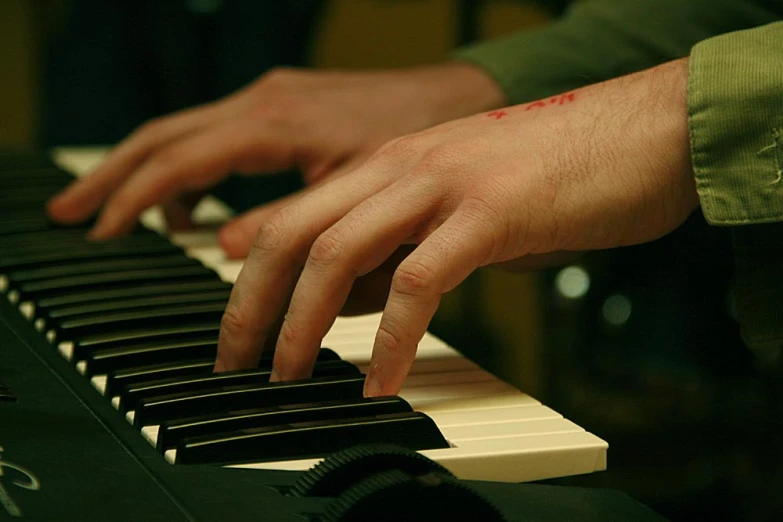 someone's hand sitting on top of an electronic keyboard