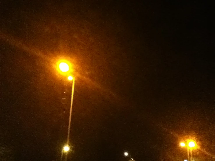 an empty street at night with yellow street lights