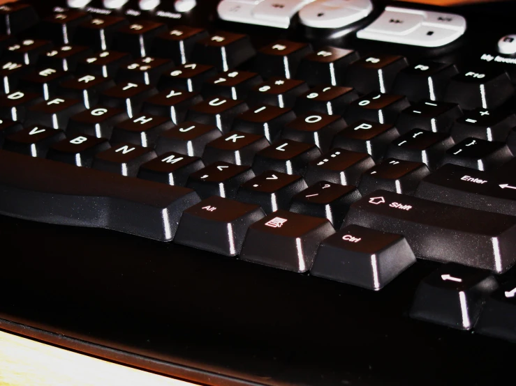 a black keyboard with white letters and pink keys