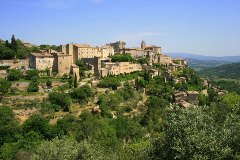 a village perched on a small hill with trees on top