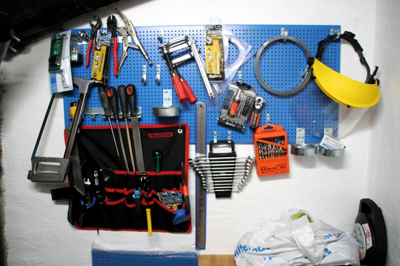 a blue pegboard is filled with various tools