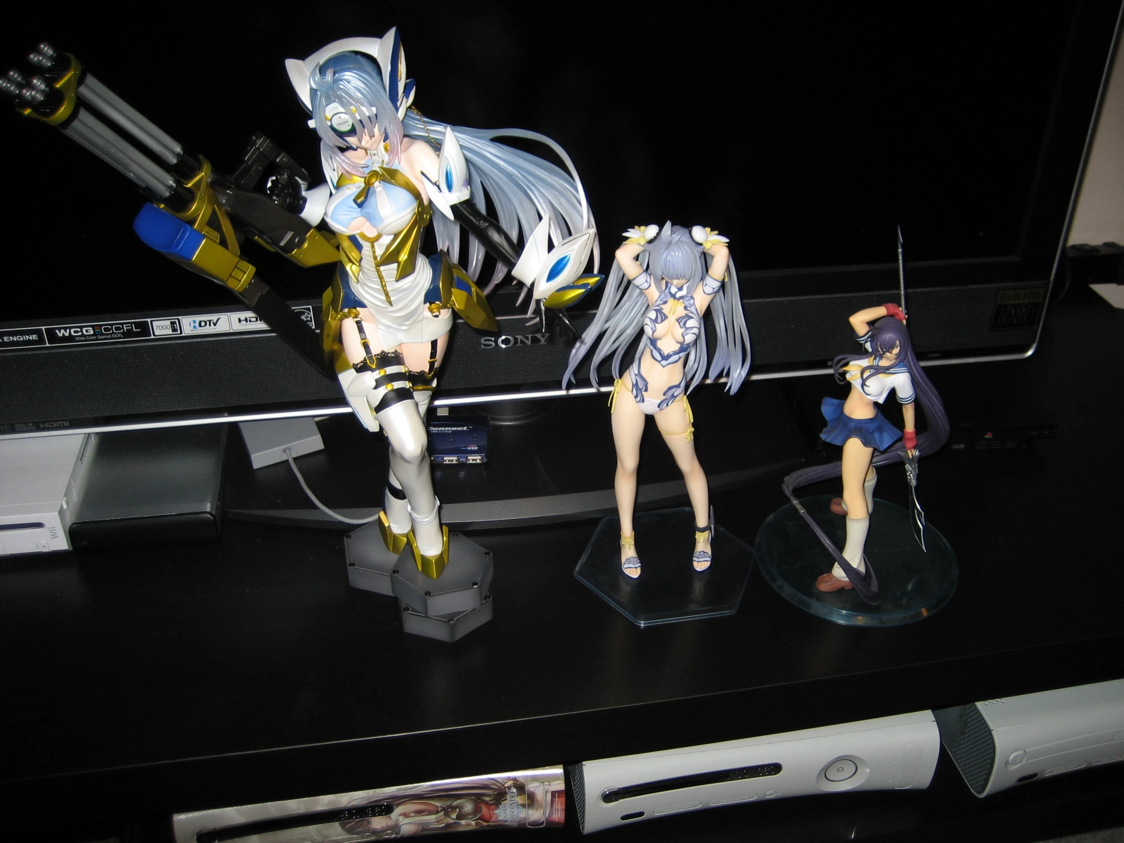 a group of figurines with a tv and some computer behind them