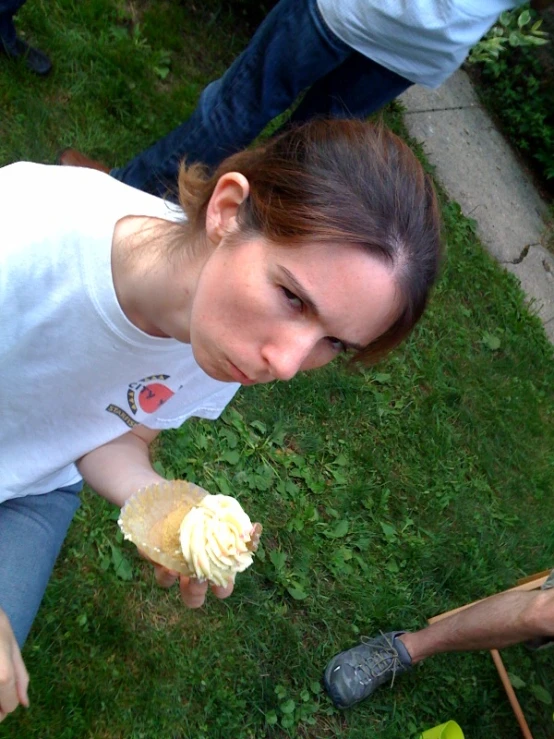 a woman holds an unwrapped pastry in her hand