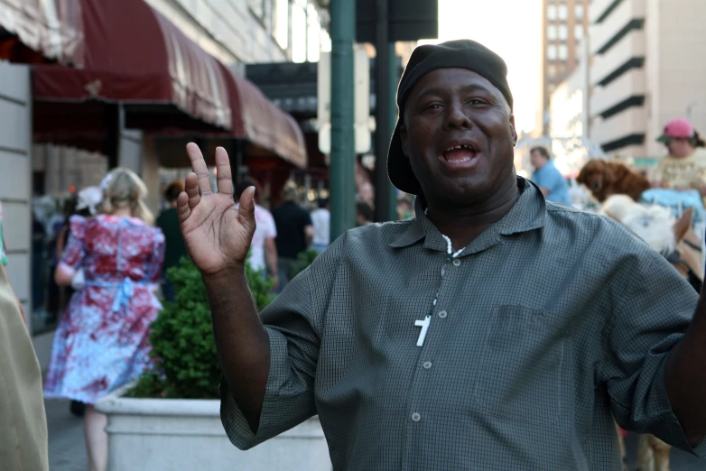 man smiling and showing victory sign with hand in city