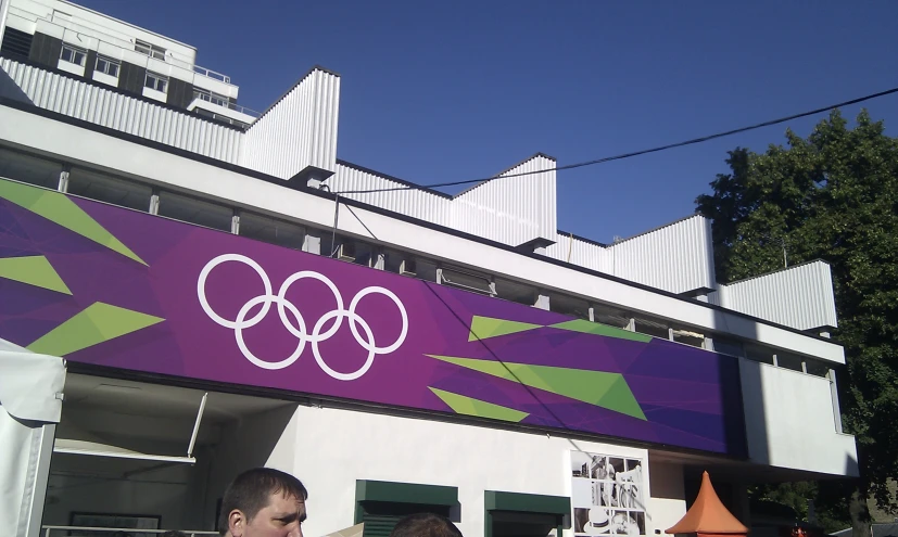 two people are standing near an olympic sign