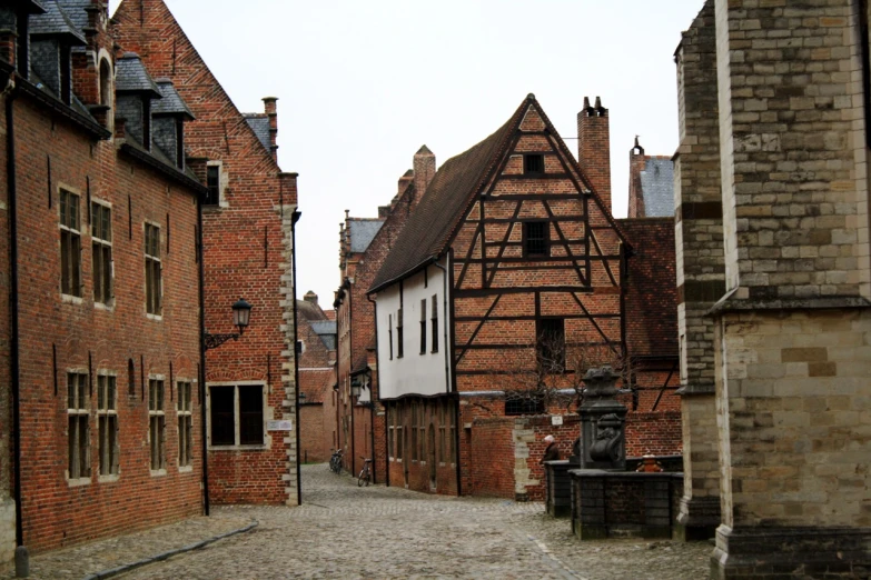 a narrow street between brick buildings with windows