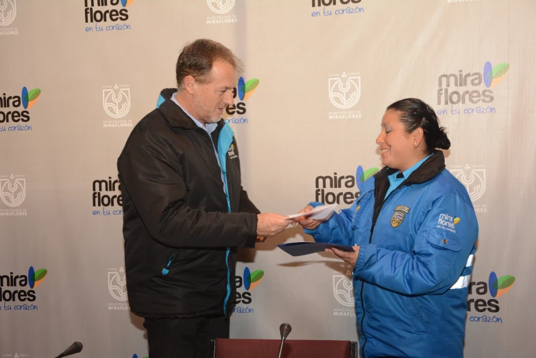 a man receiving an award from a woman