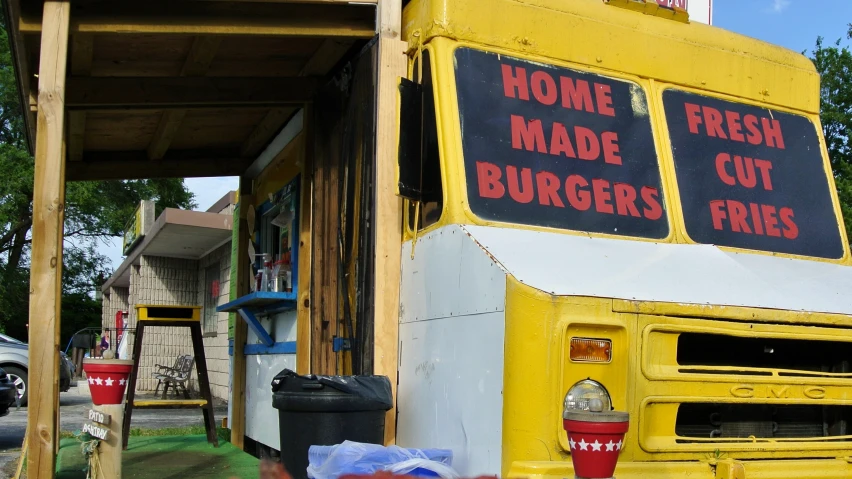 a food truck is yellow and white and has red writing