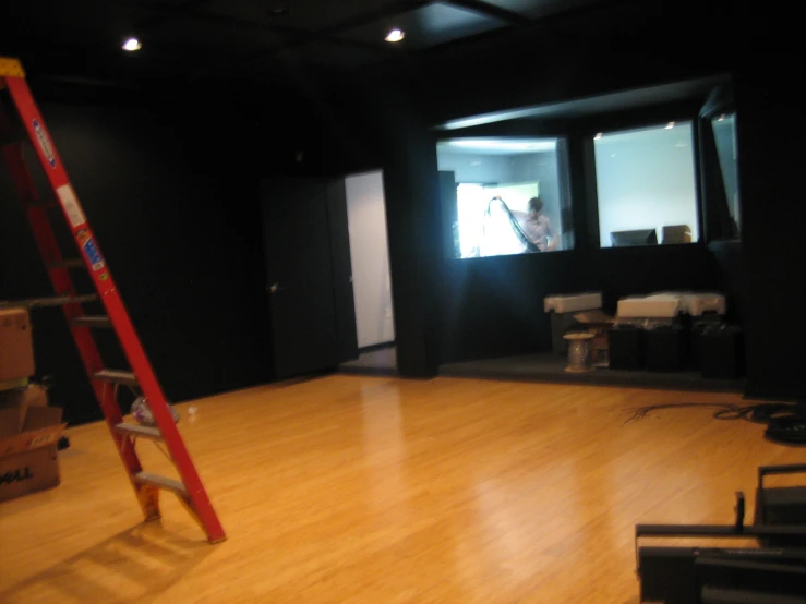 a red ladder sitting on the floor in front of a wall