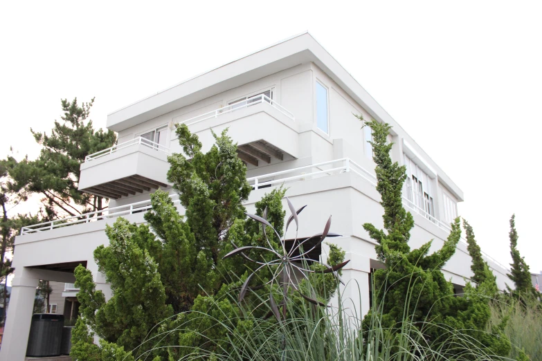 a large house with trees and bushes in the yard