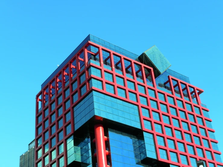 a large blue building with a red glass front