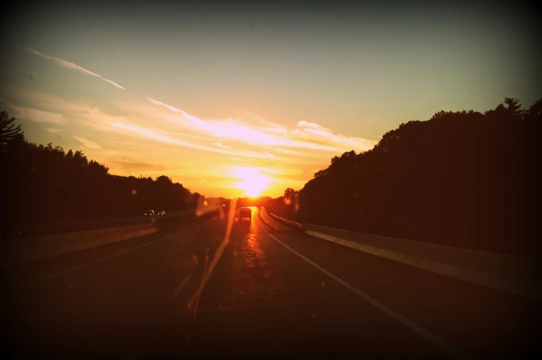 an image of a train track with the sun setting in background