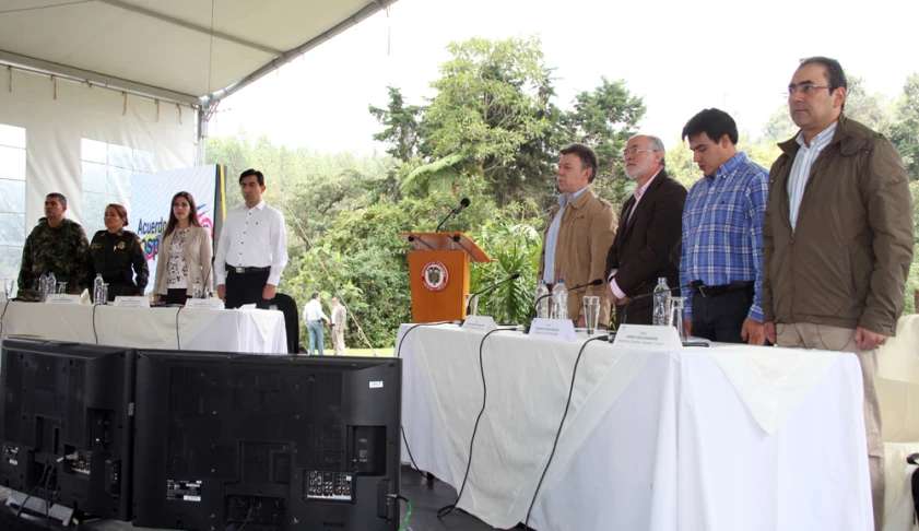 several people standing around talking on stage at an outdoor gathering