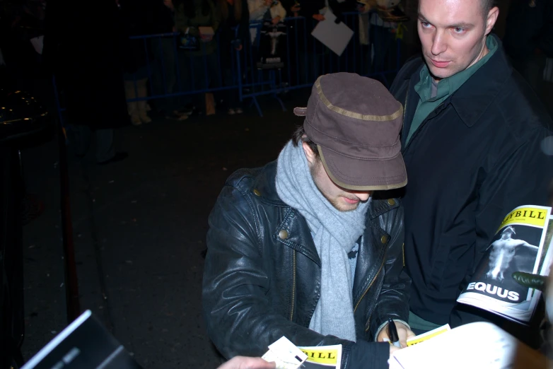 two people looking at a map while a crowd of people is in the background