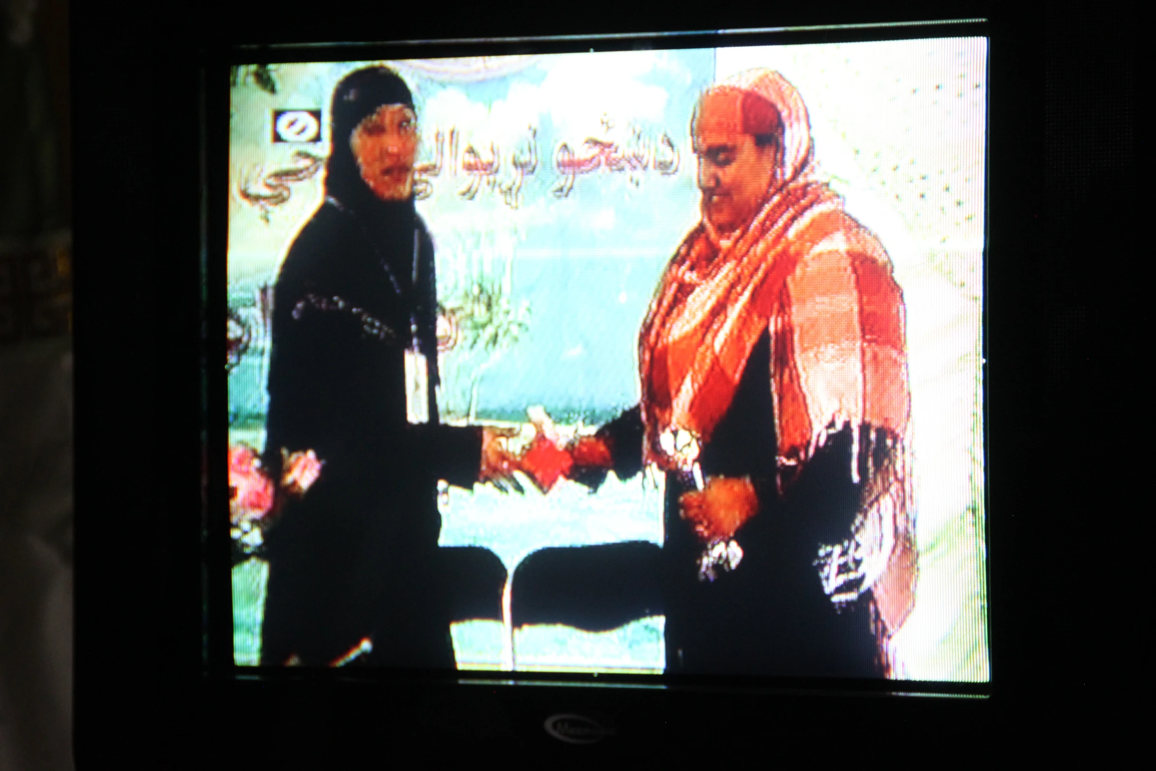 the tv is showing a show featuring two people dressed in traditional garb