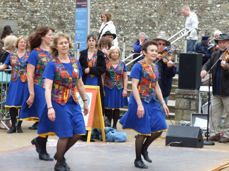 a group of women are walking through a street