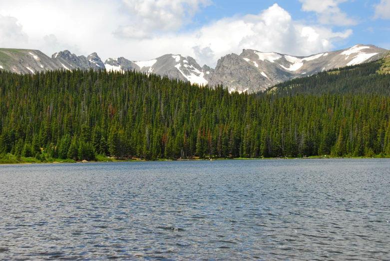 there is a boat on the water near a mountain