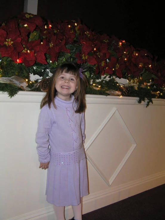 a little girl standing in front of christmas decorations