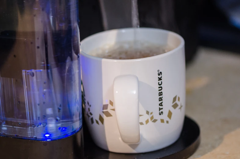 a cup of tea sits beside a juicer