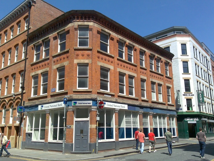 several people are walking around an old brick building