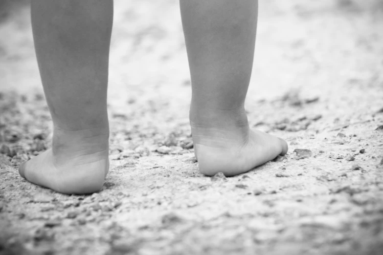 small feet sticking out from the sand on the ground